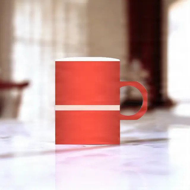 The red mug on a white marble table, its studio backdrop replaced.